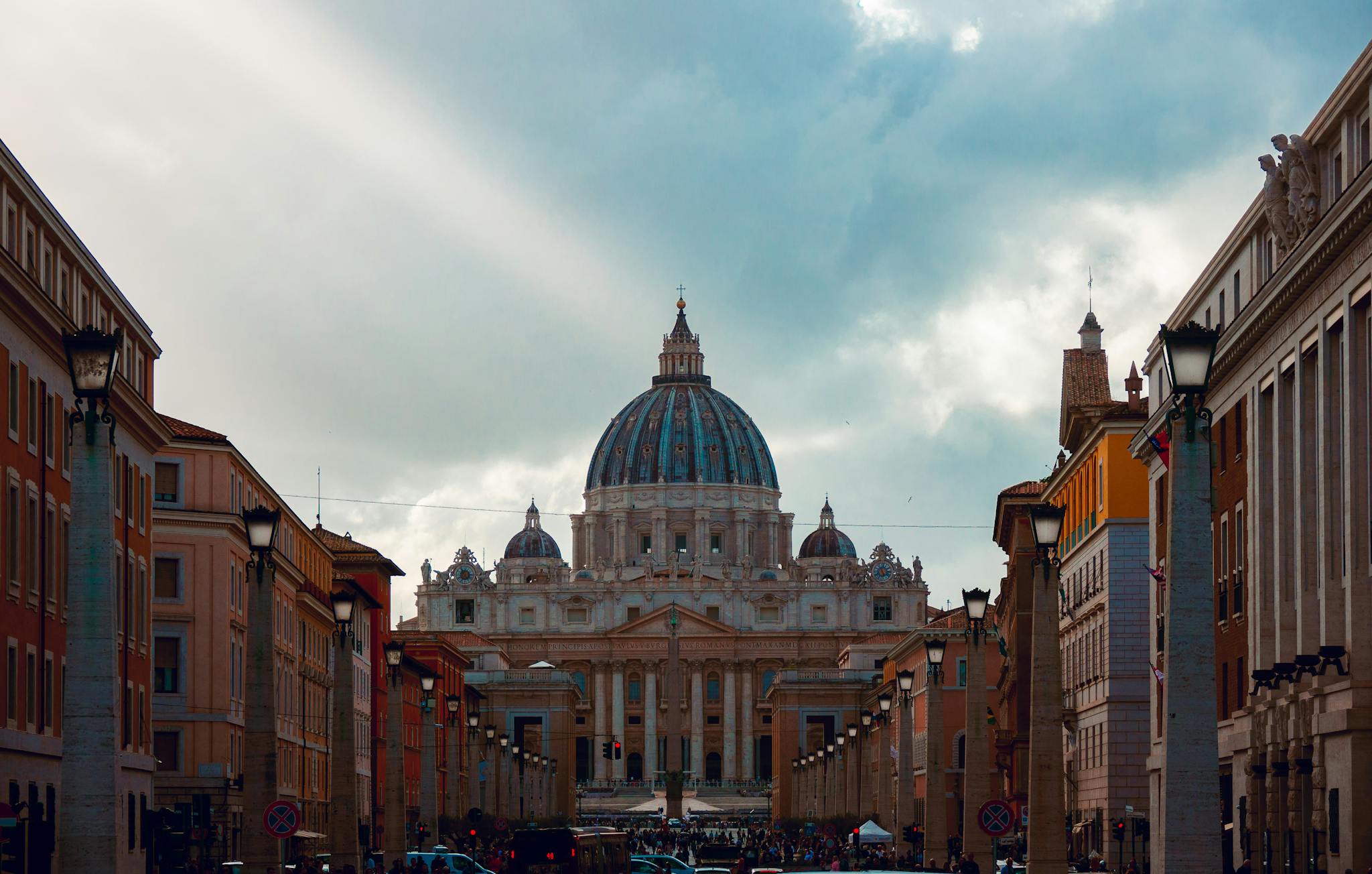 Dramatic view of St. Peter's Basilica dome in Vatican City at sunset, symbolizing majestic architecture.